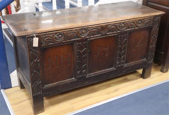 A large 18th century oak coffer, the panelled front carved with the initials M H and dated 1714 W.145cm